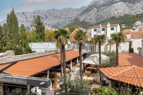 a town with palm trees and mountains in the background at Villa Riva in Makarska