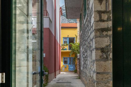 a narrow alley with a yellow and blue building at Villa Riva in Makarska