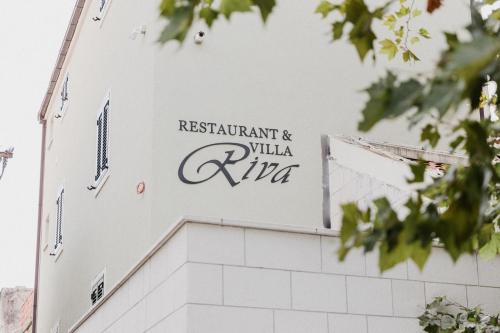 a sign on the side of a white building at Villa Riva in Makarska