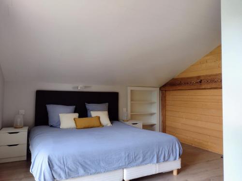 a bedroom with a blue bed and a wooden door at L'esca'Lac in Grande Riviere