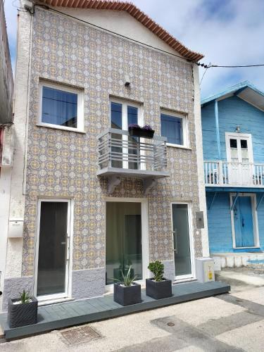 a house with a balcony on the side of it at The Violet House in Costa Nova