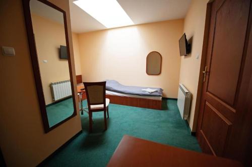 a room with a bed and a chair and a mirror at Pokoje Horyzont in Jarosław