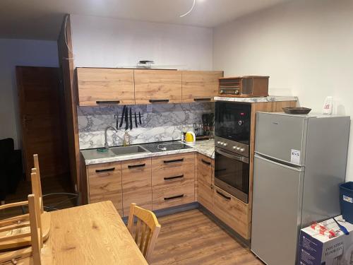 uma cozinha com um frigorífico branco e armários de madeira em Apartmany Milano s výrivkou a terasou em Kvakovce