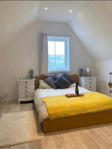 a bedroom with a bed with a yellow blanket and a window at Romantic hideaway, seconds away from Perran beach in Perranporth