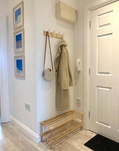 a hallway with a wooden bench next to a door at Romantic hideaway, seconds away from Perran beach in Perranporth
