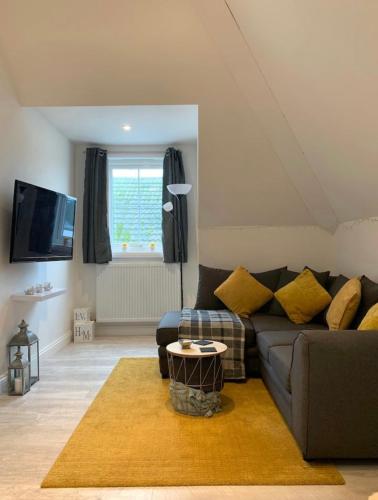 a living room with a couch and a table at Romantic hideaway, seconds away from Perran beach in Perranporth