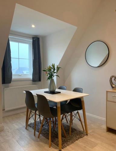 a dining room table with chairs and a mirror at Romantic hideaway, seconds away from Perran beach in Perranporth
