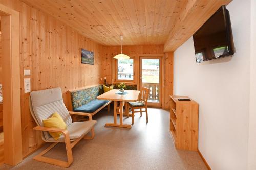 a living room with a table and chairs and a television at Appartements Willi in Schoppernau