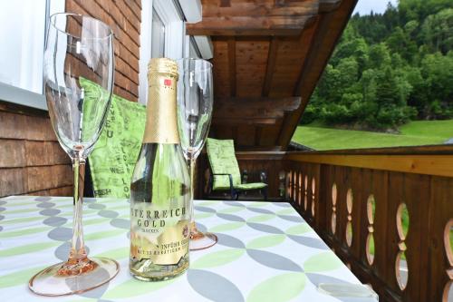 a bottle of champagne and two glasses on a table at Appartements Willi in Schoppernau
