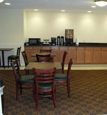 a dining room with a table and chairs and a bar at Days Inn by Wyndham Greensboro NC in Greensboro