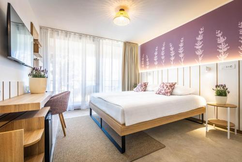 um quarto de hotel com uma cama e uma secretária em Hotel Vile Park Premium em Portorož