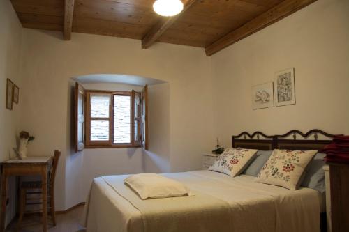 a bedroom with a bed and a window and a table at bb chiavenna centro storico in Chiavenna