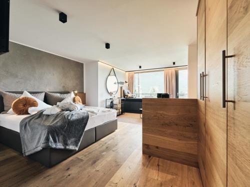 a bedroom with a bed and a large window at Hotel Auszeit in Pertisau