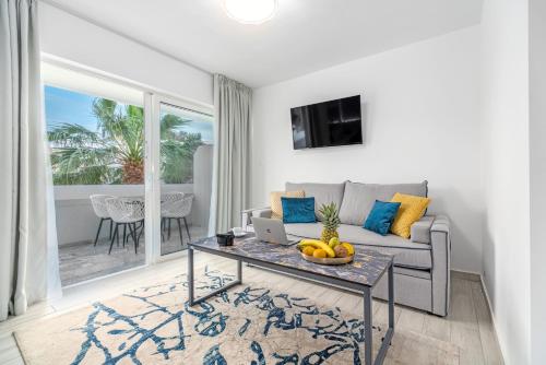 a living room with a couch and a table with a laptop at Maison 66, Riviera Hotels in Athens
