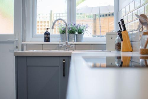 a kitchen counter with a sink and a window at Lavender Cottage - Knodishall - Newly renovated 2 bed holiday home, near Aldeburgh, Leiston and Thorpeness in Aldringham