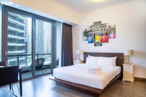 a hotel room with a bed and a large window at bnbme homes - Classic Studio Heart of the Marina - 808 in Dubai