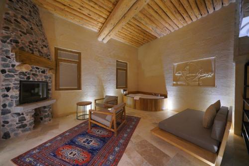 a living room with a couch and a tv at Kappadoks Cave Hotel in Uchisar
