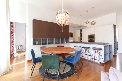 une cuisine avec une table en bois et des chaises bleues dans l'établissement Appartement 3 chambres moderne avec balcon jardin commun et Clim - BENAKEY, à Cannes