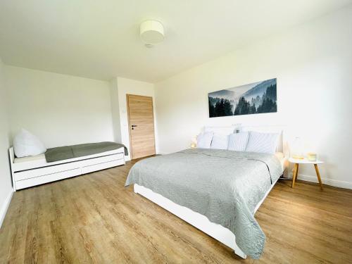 - une chambre blanche avec un lit et une fenêtre dans l'établissement Ferienwohnung Biesenzeit, à Biesenthal