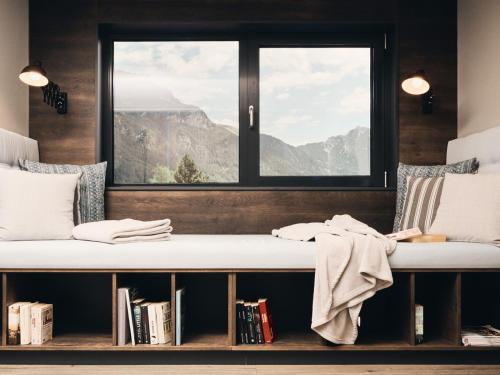 a room with a window and a bench with books at Hotel Auszeit in Pertisau