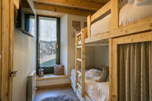 a bedroom with two bunk beds and a window at Luderna - Casa Montgarri in Naut Aran