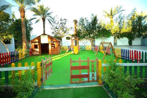 a playground in a yard with a fence at Falcon Hills Hotel in Sharm El Sheikh