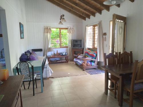 sala de estar con mesa y comedor en Cabaña Acacia Mansa en Villa Giardino