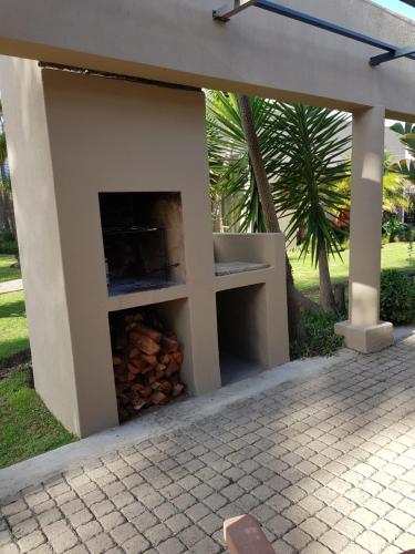 a fireplace in a building with a pile of fire wood at Bethel B&B / Selfcatering in George