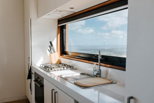 a kitchen with a sink and a window at One Tree Hill Wilson prom and Ocean views in Toora