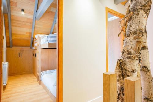 a bedroom with a bunk bed and a tree at Luderna - Casa Carboneu in Naut Aran