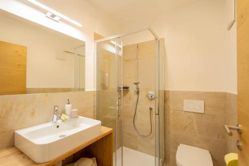 een badkamer met een wastafel en een douche bij Haus Lohengrin Ferienwohnung 1 in Siusi