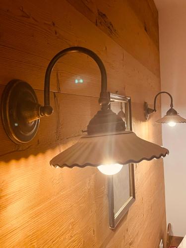 two lights are hanging on a wall at Braunegg 1 in Brunico