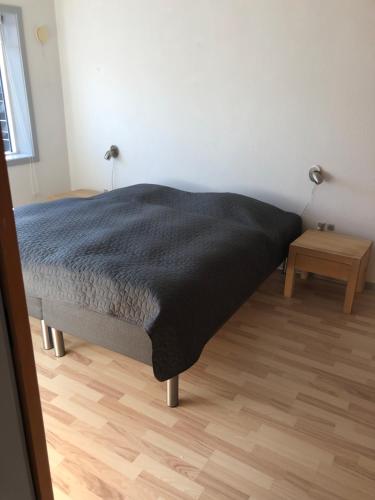 a bedroom with a bed with a black blanket at Langø, ferielejlighed in Nakskov