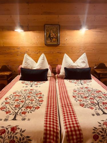 a bedroom with two beds with red and white sheets at Braunegg 1 in Brunico