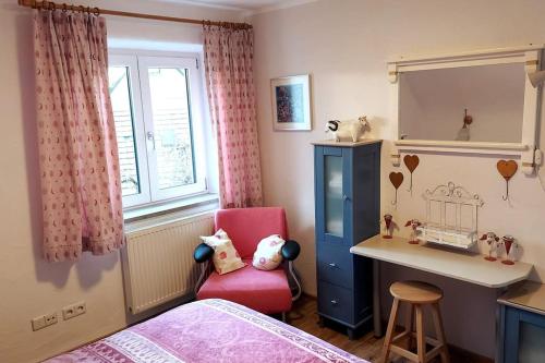 Dormitorio infantil con escritorio y silla rosa en gemütliche Ferienwohnung auf 2 Etagen mit Dachterrasse, en Wangen im Allgäu