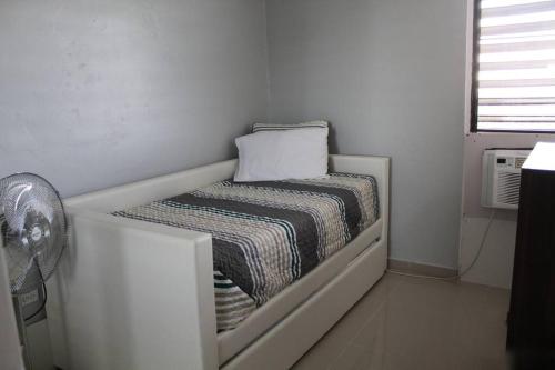 a white room with a bed and a fan at Penthouse Views in San Juan