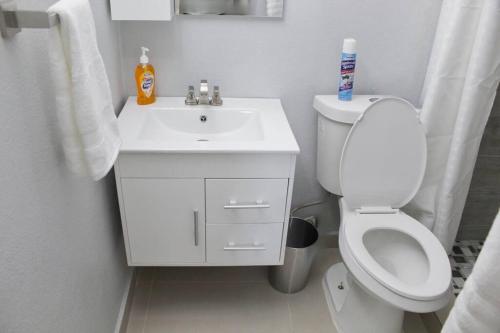 a white bathroom with a toilet and a sink at Penthouse Views in San Juan