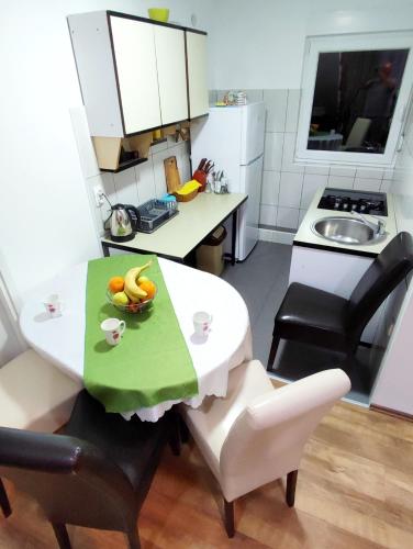 a kitchen with a table with a bowl of fruit on it at Apartments and Rooms Minex in Trebinje