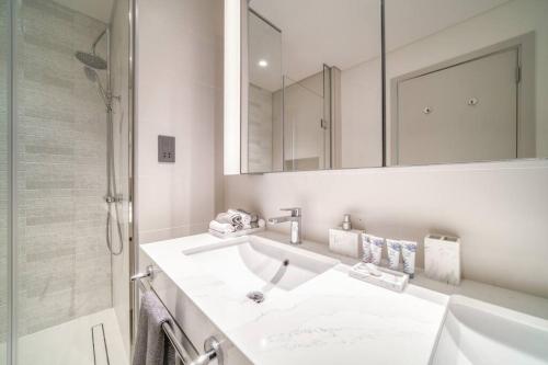 a white bathroom with a sink and a mirror at Sunrise Bay, Emaar Beachfront Dubai Harbour - Mint Stay in Dubai