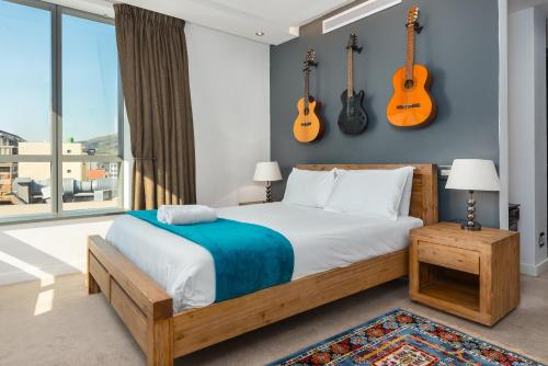 een slaapkamer met een bed met gitaren aan de muur bij Mandela Rhodes Luxury Apartments in Kaapstad