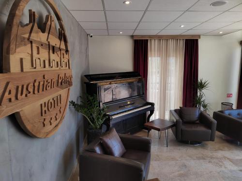 a living room with a tv and a couch and chairs at Austrian Palace Hotel in Skopje