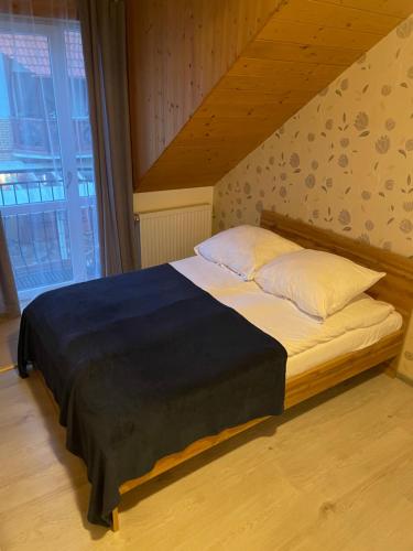 duże łóżko w pokoju ze schodami w obiekcie Pokoje Sztormowa 15 w Pogorzelicy