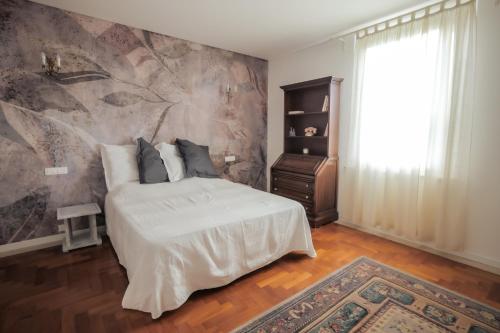 a bedroom with a bed and a painting on the wall at L'Andito in Carpi