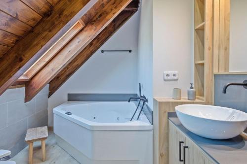 a bathroom with a white tub and a sink at Luderna - Tríplex Val de Ruda E3 der Humarau in Naut Aran