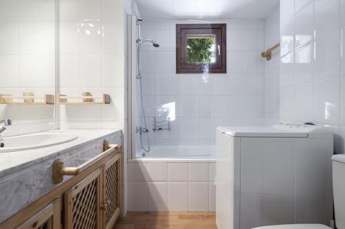 a white bathroom with a shower and a sink at Luderna - Apartamento Tanau A2 Esquirós 2 in Naut Aran