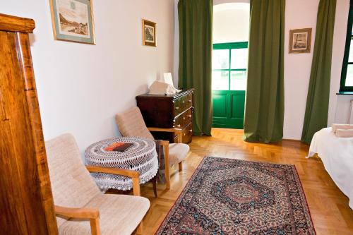 a living room with a bed and a chair and a table at Barta Pince Vendégház Mád in Mád