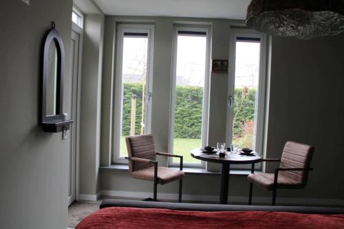 ein Zimmer mit einem Tisch, zwei Stühlen und einem Fenster in der Unterkunft GRUTSK in Workum