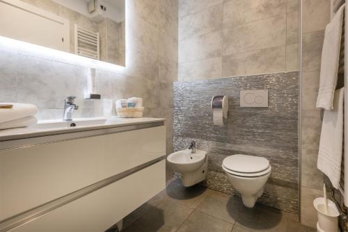 a bathroom with a toilet and a sink at Hotel De Nac in Nago-Torbole