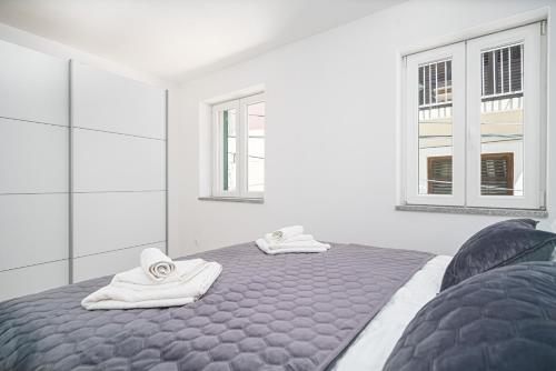 a bedroom with two beds and two windows at Villa Pia in Vodice
