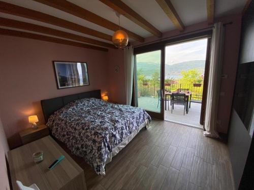 a bedroom with a bed and a large window with a table at Palmito Villa in Baveno